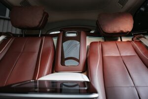 Close-up view of the rear seats with brown leather car interior upholstery, featuring a central armrest and seat headrests—showcasing premium craftsmanship in New Orleans.